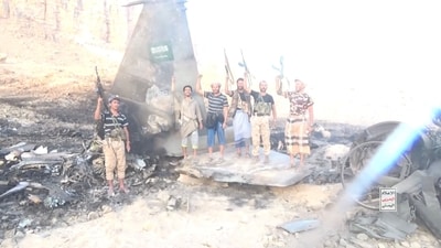 Houthi fighters stand in front of what they claim is a downed Saudi jet at a location identified as Yemen, in this still image taken from a handout video released on September 16, 2026. Houthi Military Media/Handout via REUTERS.