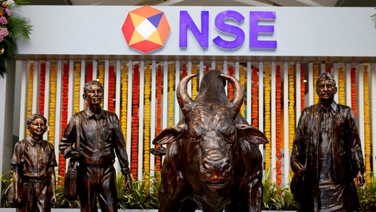 Stock market Sep 17: Statues of people and a bull are seen next to the logo of the National Stock Exchange (NSE) in Mumbai