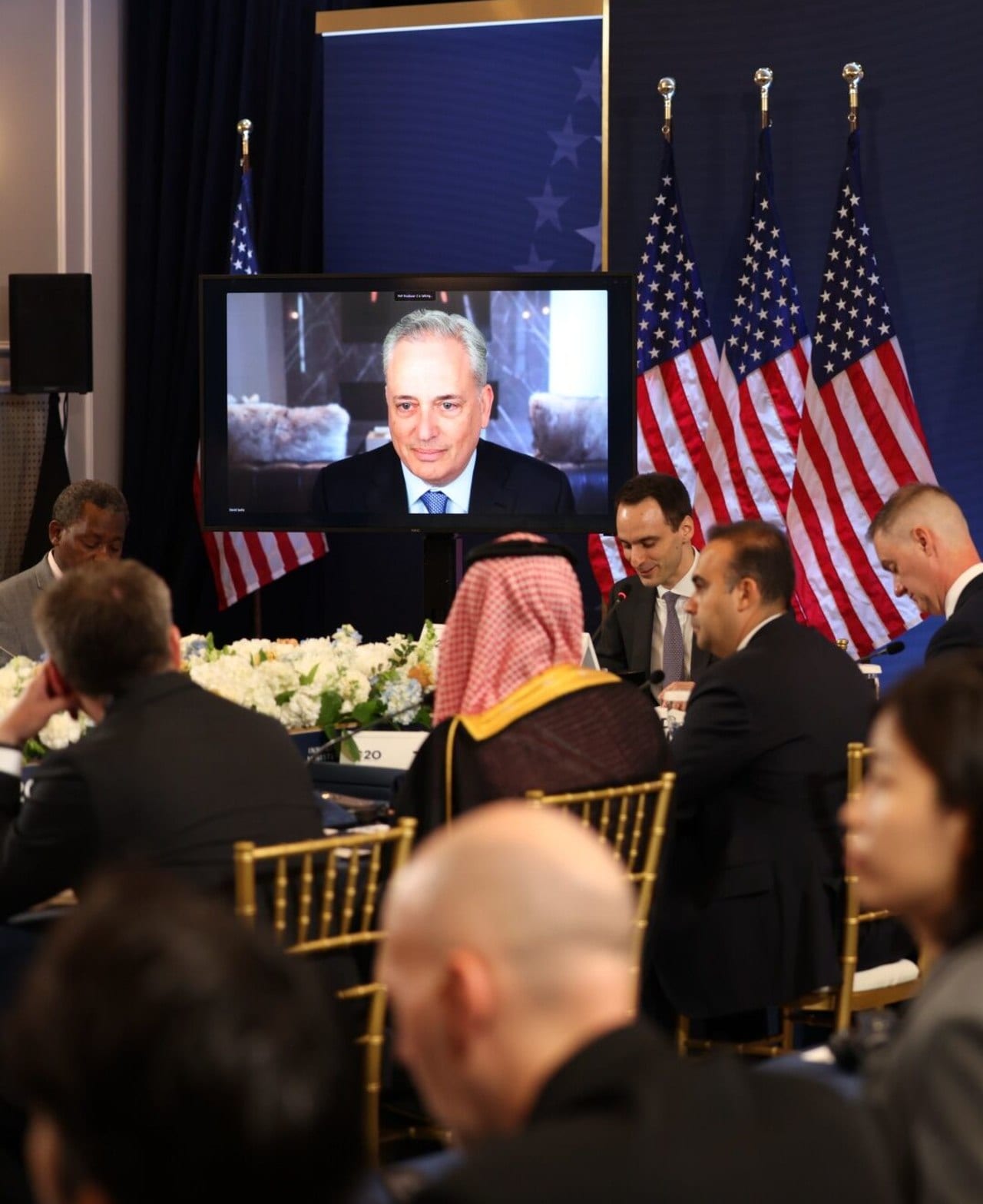 White House AI adviser David Sacks, speaking virtually at a meeting, holds stakes in SpaceX and numerous AI startups through his venture firm.