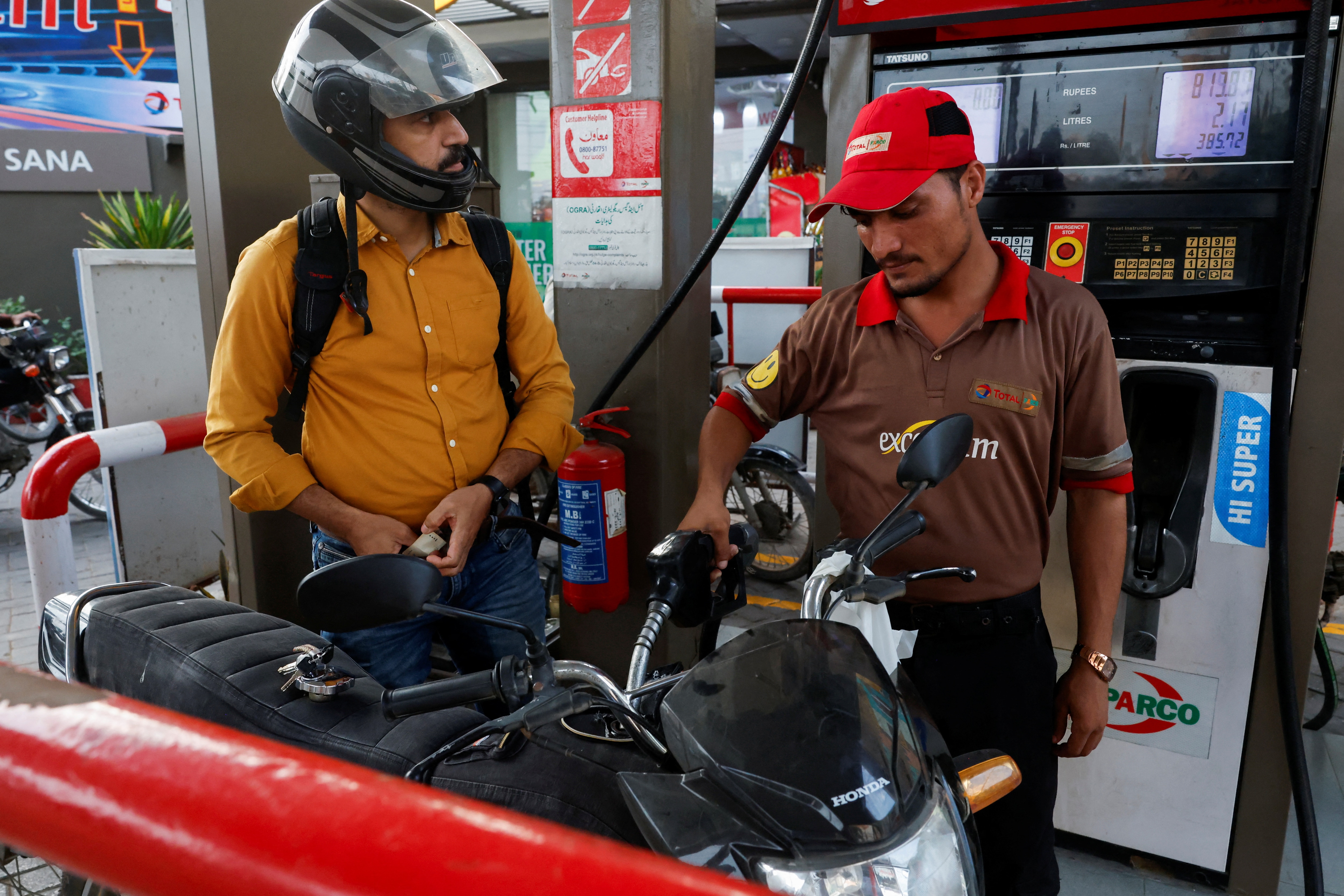 A man watches the litres and rupee amount displayed at the pump as he refuels his vehicle at a petrol station, as fuel prices rise amid the U.S.-Iran conflict (Reuters)