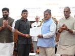 Chandigarh administrator Gulab Chand Kataria presents certificates to a Bharat Taxi driver in the presence of Union MoS for cooperation and civil aviation Murlidhar Mohol (extreme left) and MoS for cooperation Krishan Pal Gurjar. (Keshav Singh/HT)