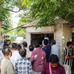 People gather as police inspect the site after Surendra Koli was found dead in Haridwar.