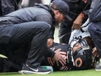Chicago Bears quarterback Caleb Williams lies on the field after suffering hamstring injury.
