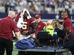 Jayden Daniels #5 of the Washington Commanders looks on before being carted off the field after sustaining an injury against the Dallas Cowboys in the second quarter of a game at AT&T Stadium in Arlington, Texas.(Getty Images via AFP)