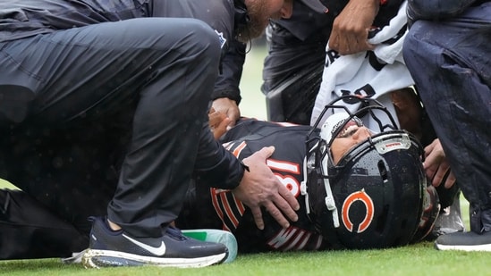 Chicago Bears quarterback Caleb Williams lies on the field after suffering hamstring injury.