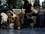 Passengers rest at Haneda Airport as many flights are delayed and cancelled due to Typhoon Dujuan, in Tokyo, Japan, September 21, 2026.(REUTERS)
