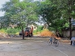 An earth moving machine deployed to clear waste accumulated near Guru Nanak Public School at Model Town Extension in Ludhiana on Sunday. (HT Photo)