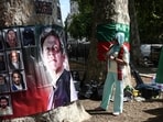 A woman looks at a banner showing Pakistan's jailed former prime minister Imran Khan (L) as a small group of people hold a rally opposite Downing Street in central London on August 23, 2026. 