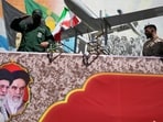 A member of Iran's Revolutionary Guard salutes while riding on a float displaying drones during the state-organized "Janfada," or "Sacrifice for Iran," military-style parade in Tehran.