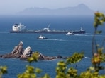 Tugboats guide a crude-oil tanker after passing through the Strait of Hormuz in May.