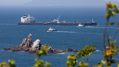 Tugboats guide a crude-oil tanker after passing through the Strait of Hormuz in May. Tugboats guide a crude-oil tanker after passing through the Strait of Hormuz in May.