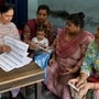 A Booth Level Officer (BLO) helps voters check their names in the newly released Draft Electoral Roll 2026 as part of the Election Commission of India's Special Intensive Revision (SIR), at a voter verification camp inside a polling station in Amritsar on August 16, 2026. (Photo by Narinder NANU / AFP)
