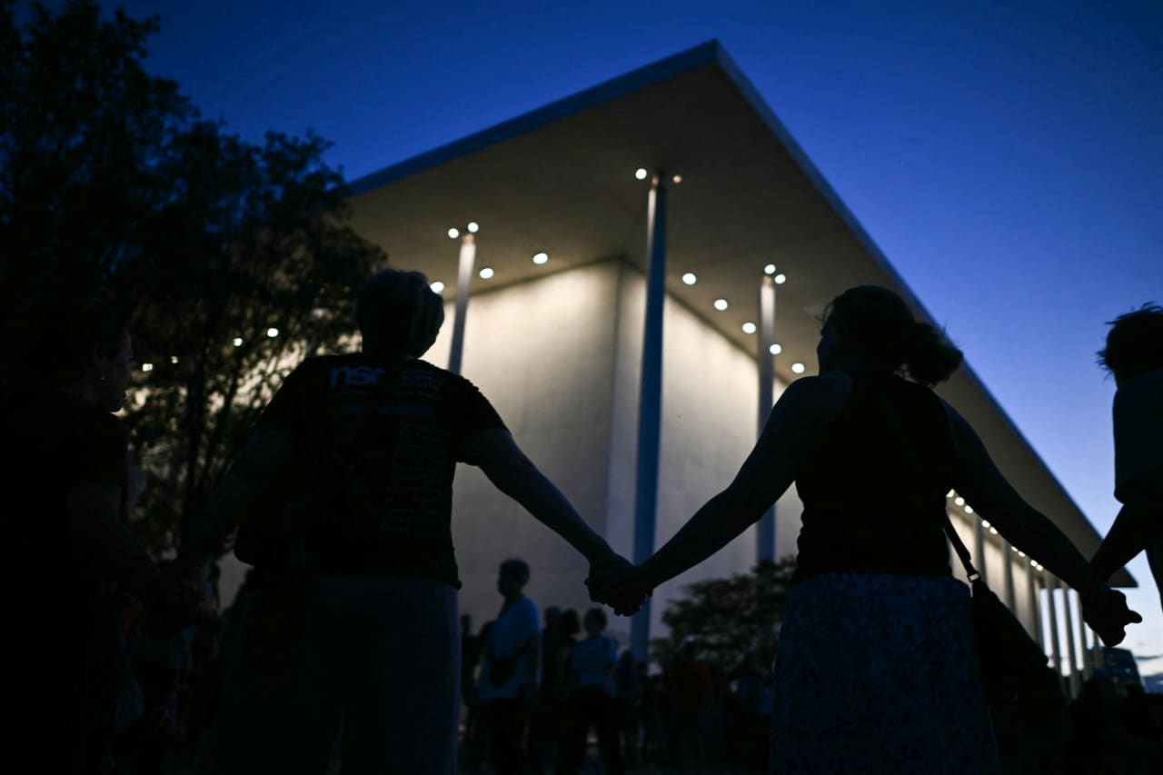 People holding hands during a rally Friday night in support of the Kennedy Center. People holding hands during a rally Friday night in support of the Kennedy Center.