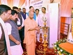 Chief minister Yogi Adityanath lights a ceremonial lamp during the Shakti Kendra convenor conference, in Meerut on Monday. BJP national president Nitin Nabin and other leaders also present. (ANI PHOTO)