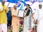 Uttar Pradesh CM Yogi Adityanath distributing an appointment letter to a candidate at an event in Lucknow on September 22. (ANI)