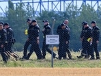 FILE PHOTO: A police officer in protective clothing works at Leipzig/Halle Airport in Schkeuditz, Germany, August 5, 2026, after the police said explosives experts examined a drone near a runway, and after a DHL cargo aircraft hit an unknown object as it was climbing away from the airport overnight, prompting an unscheduled landing in Hanover, according to a source familiar with the incident. 