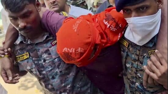 Jamui: Security personnel carry an accused allegedly involved in the harassment of a boy and a girl by the roadside, after he was shot in leg during a police encounter, in Jamui on Tuesday. (PTI)