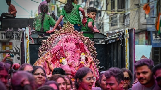 Devotees immerse an idol of Lord Ganesh in the water pond created by the Delhi government on the Ganesh Chaturthi festival in Delhi