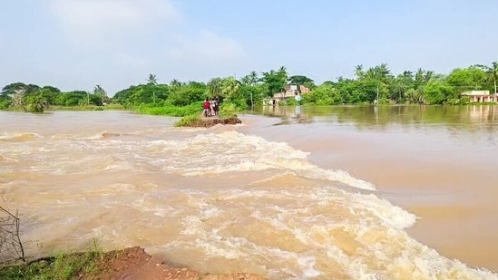 File photo: People stand on a small elevated patch of land surrounded by strong floodwaters, amid the flood situation, in Kendrapara, Odisha