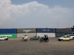 Vehicles move past shipping containers used to block the area ahead of a planned march by former Pakistani Prime Minister Imran Khan's party, demanding his release and calling for the supremacy of the Constitution and restoration of the rule of law across the country, in Islamabad.