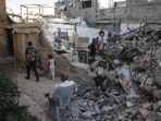 Displaced Palestinians gather amid the rubble of a heavily damaged building being used as a shelter in Khan Yunis in the southern Gaza Strip.