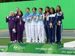 The Indian women's skeet team (R) celebrates on the podium after clinching bronze.