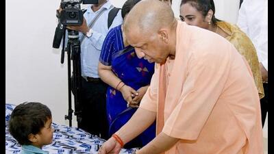 Chief minister Yogi Adityanath meets a child during the inauguration of a state women’s shelter, in Gorakhpur. ((@myogiadityanath/X via PTI Photo))