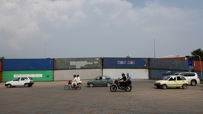 Vehicles move past shipping containers used to block the area ahead of a planned march by former Pakistani Prime Minister Imran Khan's party, demanding his release and calling for the supremacy of the Constitution and restoration of the rule of law across the country, in Islamabad. (REUTERS)