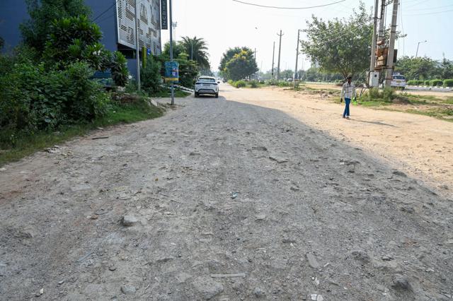 A cratered stretch of the service road near Astaire Gardens Society as seen on Tuesday. (Parveen Kumar/Hindustan Times) A cratered stretch of the service road near Astaire Gardens Society as seen on Tuesday. (Parveen Kumar/Hindustan Times)