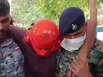 Security personnel carry an accused allegedly involved in the harassment of a boy and a girl by the roadside, in Jamui, Bihar.