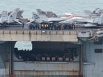 Personnel and aircraft on the deck of the US Navy Nimitz-class aircraft carrier USS Abraham Lincoln as it sails toward Laem Chabang Port .