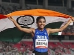 India’s Seema holds the national flag as she celebrates after winning the bronze medal in the women's 10,000m final during the Asian Games 2026. (PTI)