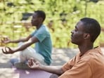 A representative image of two people practising meditation.