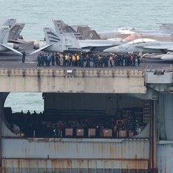 Personnel and aircraft on the deck of the US Navy Nimitz-class aircraft carrier USS Abraham Lincoln as it sails toward Laem Chabang Port .