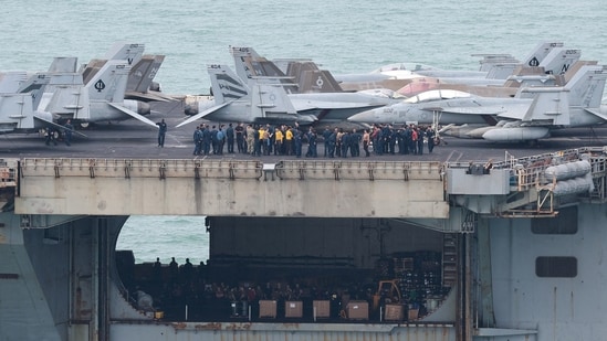Personnel and aircraft on the deck of the US Navy Nimitz-class aircraft carrier USS Abraham Lincoln as it sails toward Laem Chabang Port .