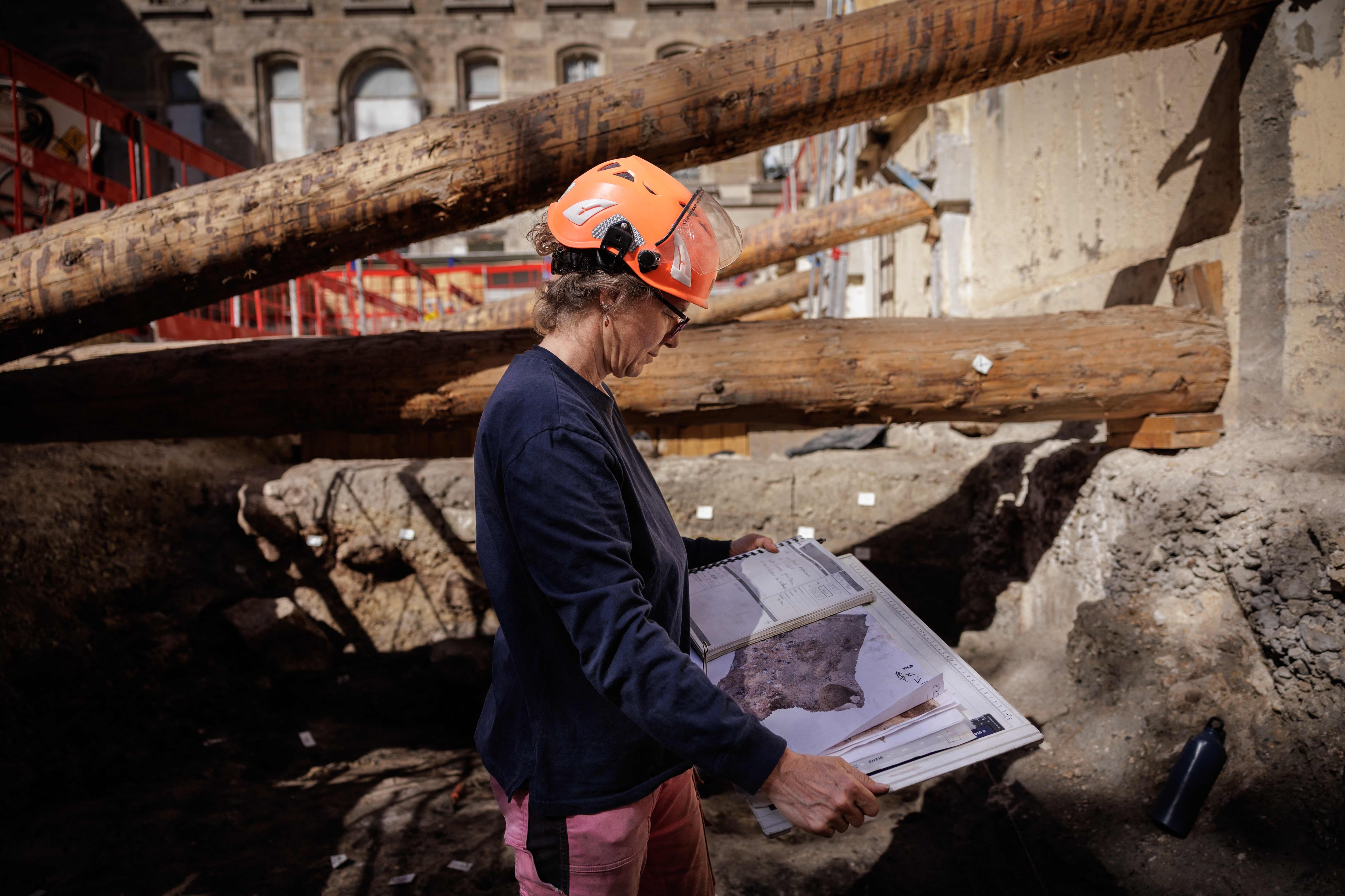 Elodie Perugini, archeologist for the city of Paris, looks at a map of the site during excavations at an archaeological site under the Hotel-Dieu hospital. (AFP) Elodie Perugini, archeologist for the city of Paris, looks at a map of the site during excavations at an archaeological site under the Hotel-Dieu hospital. (AFP)