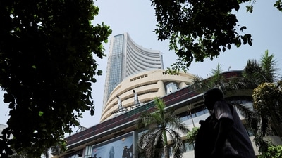 Men walk past a screen displaying market results outside the Bombay Stock Exchange (BSE) in Mumbai. (REUTERS)