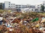 A heap of garbage dumped in a plot behind a private school in Ludhiana on Saturday. (Gurpreet Singh/HT)