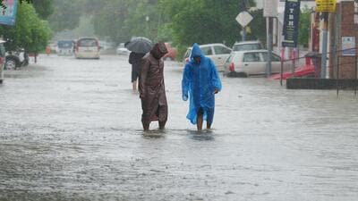 People wading through a waterlogged road in Ashiana area of Lucknow on Saturday. (Deepak Gupta/HT Photo)
