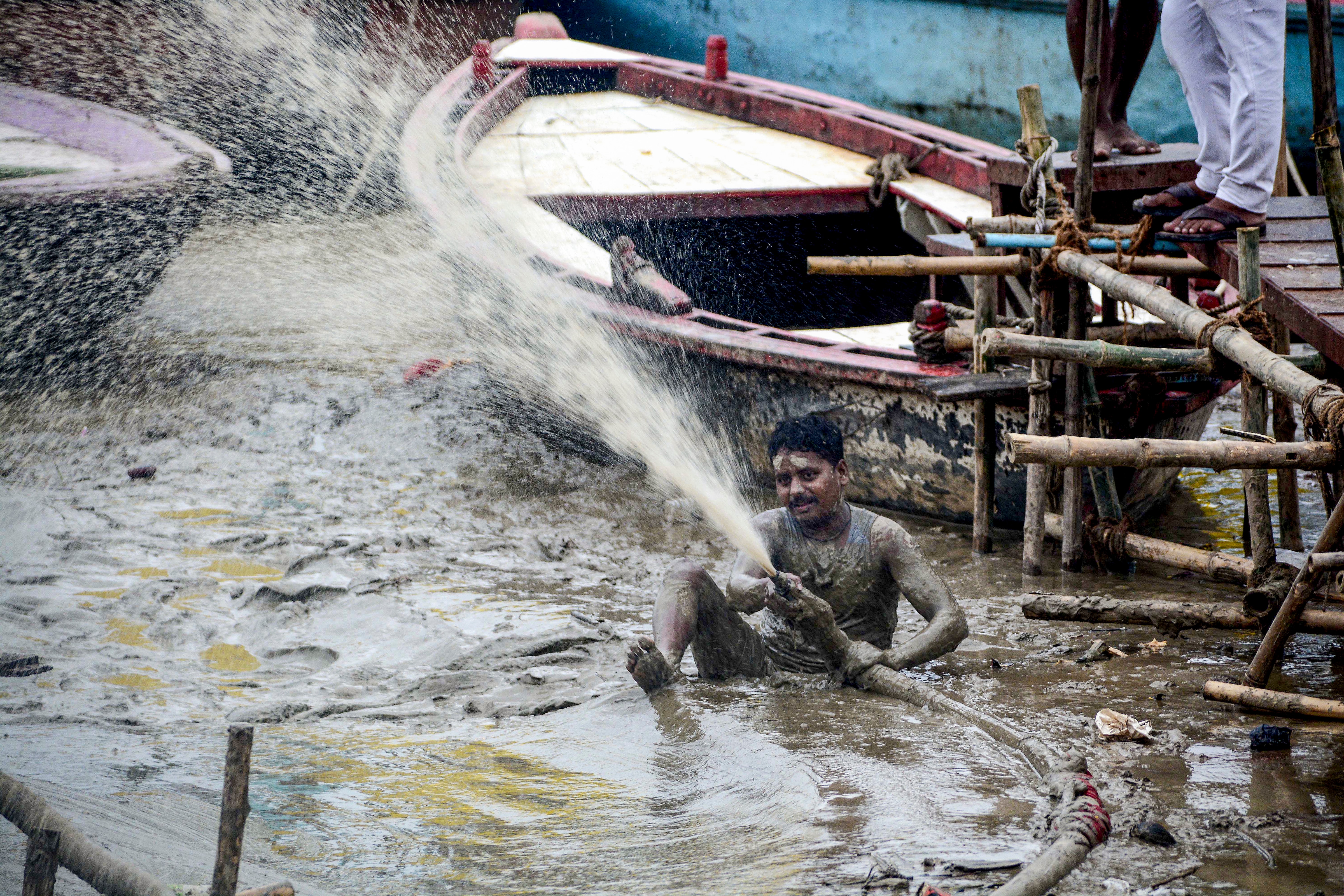 A man clears sludge after floodwater of the swollen Ganga receded at Assi Ghat, in Varanasi, Uttar Pradesh, Saturday, Sept. 26. (PTI) A man clears sludge after floodwater of the swollen Ganga receded at Assi Ghat, in Varanasi, Uttar Pradesh, Saturday, Sept. 26. (PTI)