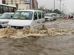 Commuters wade through a waterlogged road following heavy rainfall at Ashiana Colony, in Lucknow on Saturday. (ANI)