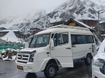 A tourist vehicle moving through the snow covered area at Chitkul in Kinnaur district on Sunday. (Deepak Sansta)