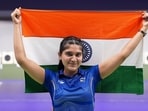 Esha Singh poses with the national flag after winning the silver medal in the women's 25m pistol event.