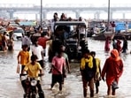 People carry their belongings to safer places along the banks of the Ganga river as the water level rises following heavy rain in Prayagraj on Monday (PTI)