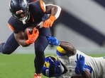 Denver Broncos running back RJ Harvey, left, is tripped up by Los Angeles Rams linebacker Byron Young during the first half of an NFL football game Sunday. (AP Photo/David Zalubowski)