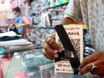 A shopkeeper ties a black band on a QR code scanner at his shop to protest against the implementation of Merchant Discount Rate (MDR) in UPI transactions(ANI)
