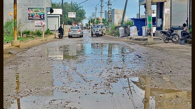 A damaged road and garbage strewn along the road in Ward 23 , Ludhiana. (Gurpreet singh/HT)