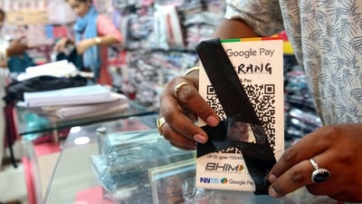 A shopkeeper ties a black band on a QR code scanner at his shop to protest against the implementation of Merchant Discount Rate (MDR) in UPI transactions (ANI)