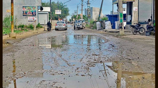 A damaged road and garbage strewn along the road in Ward 23 , Ludhiana. (Gurpreet singh/HT)
