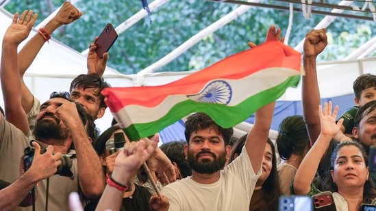 Abhijeet Dipke, with supporters, celebrates at Delhi's Jantar Mantar after education minister Dharmendra Pradhan resigned.